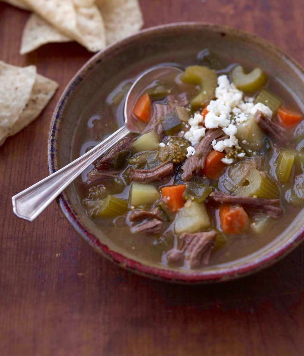 Mexican Tomatillo and Shredded Beef Soup in rustic bowl w chips on side