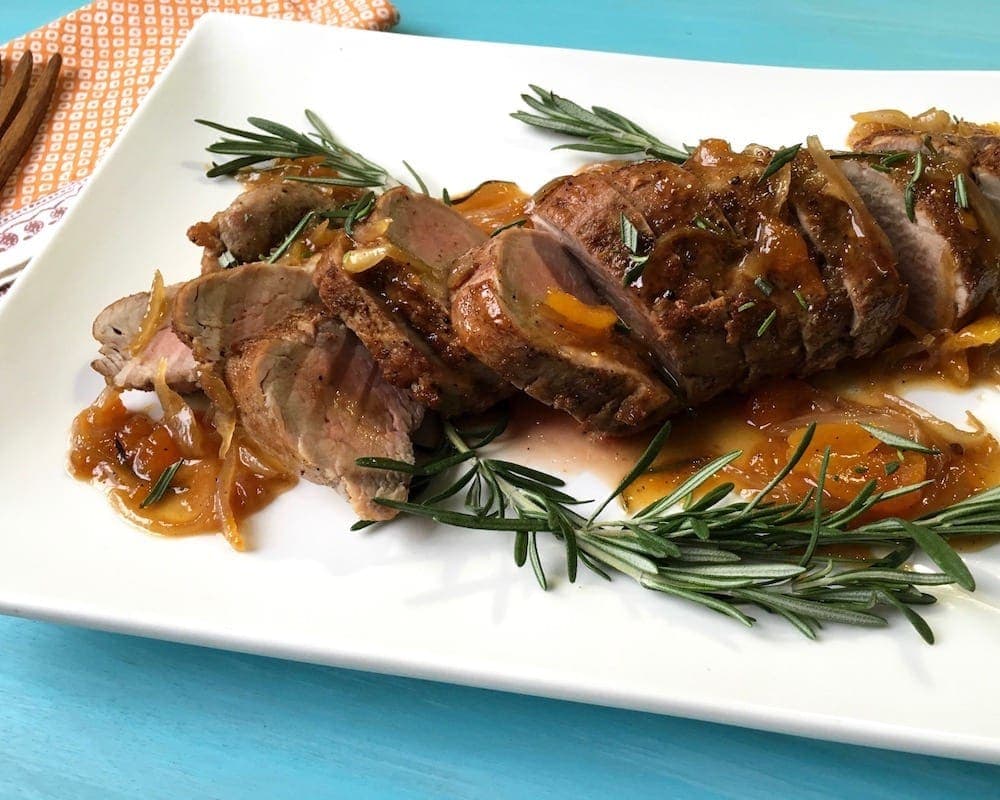 Tenderloin with sauce and rosemary on white plate
