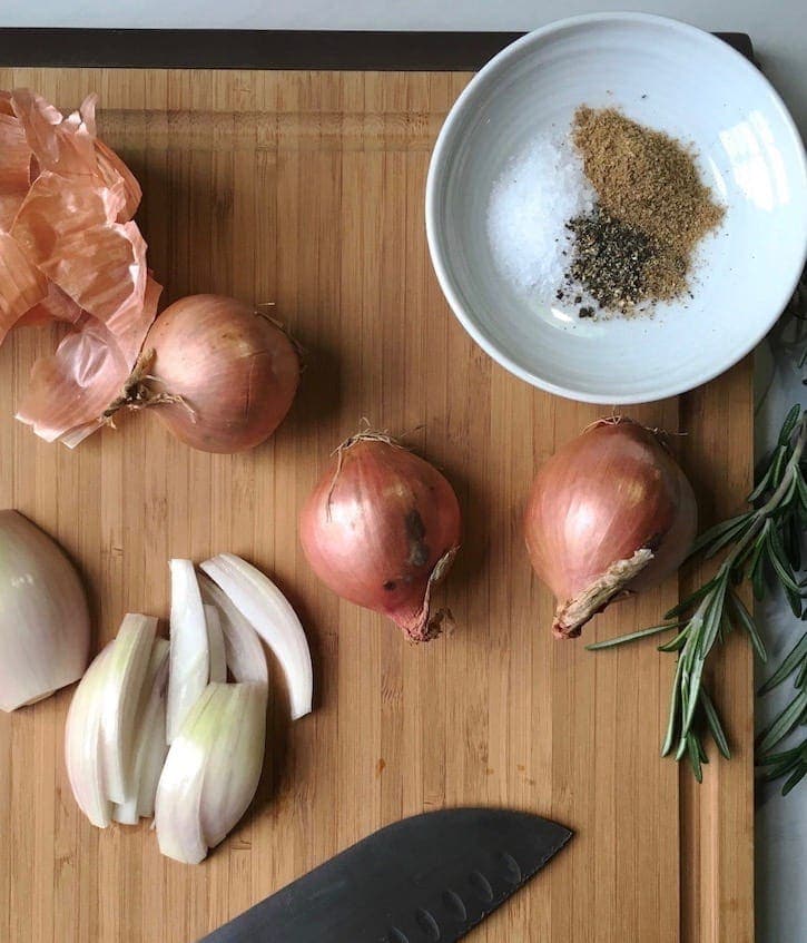 Shallots cut and whole plus seasonings on cutting board