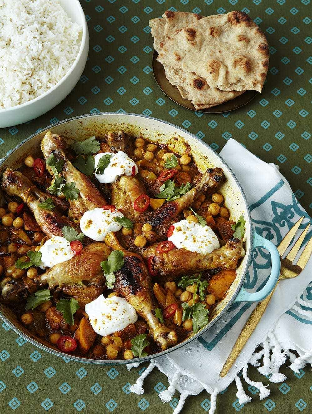 Curry Chicken Drumsticks with Chickpeas in saute pan with rice and naan.
