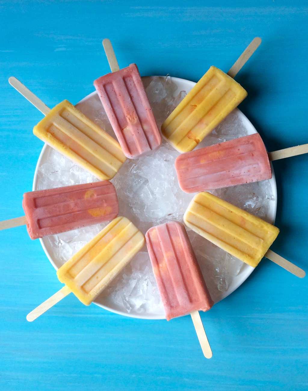 Halos Mandarins Frozen Smoothie Pops on ice with turquoise background