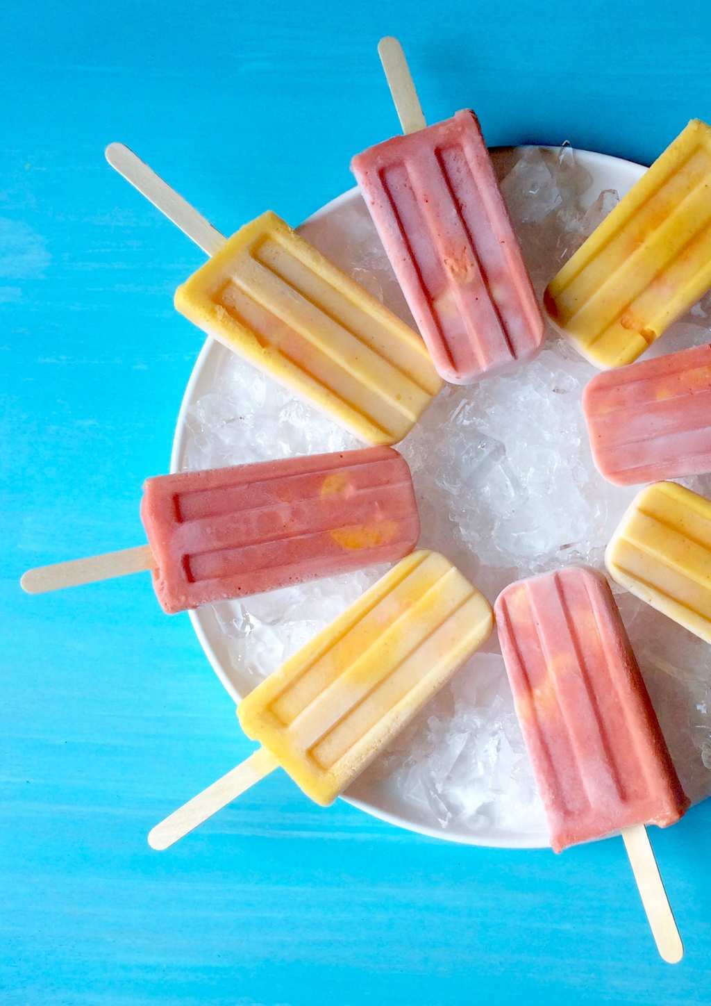 Halos Mandarins Frozen Smoothie Pops on ice with turquoise background