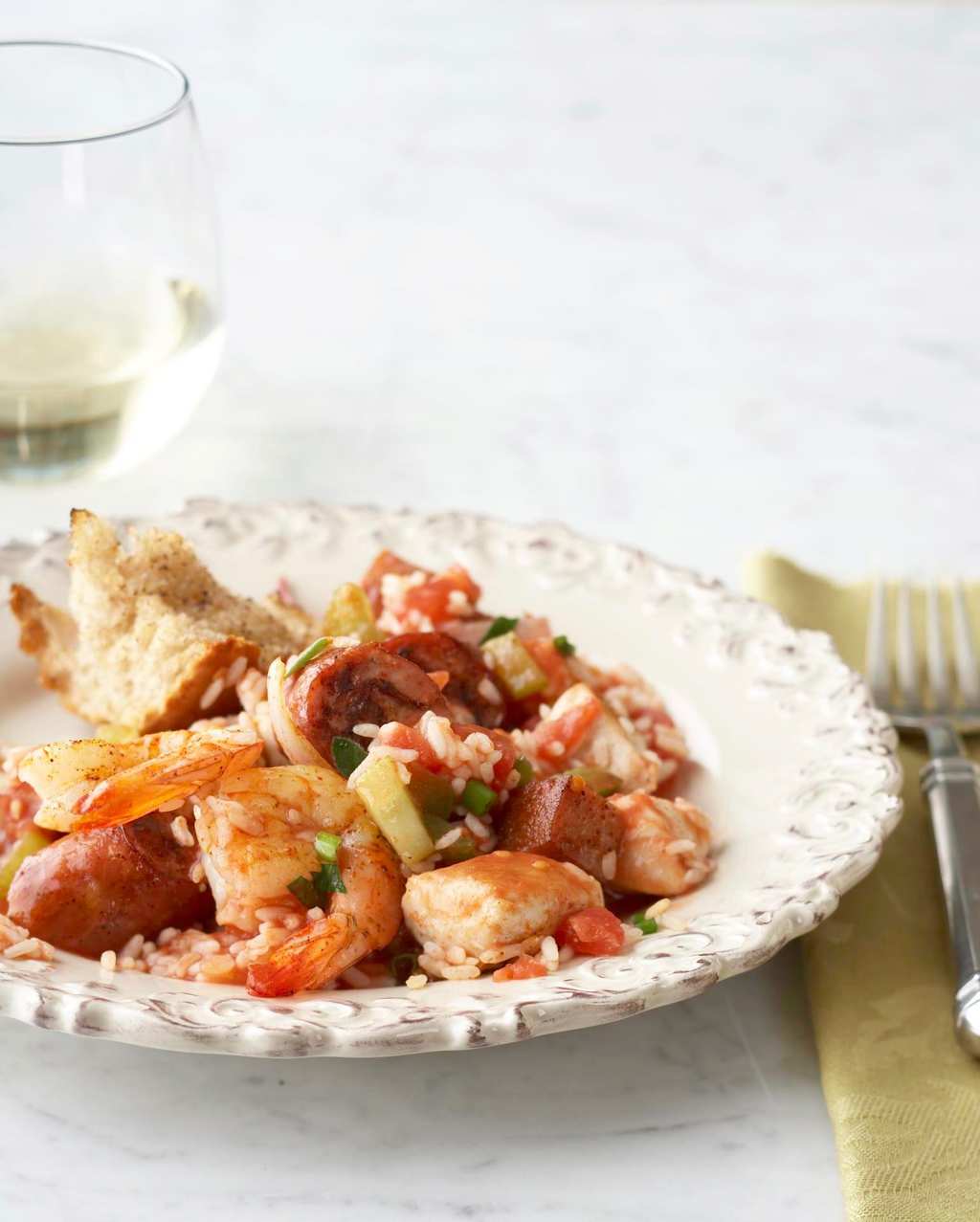 Classic Creole One Pan Jambalaya in white bowl with gold napkin