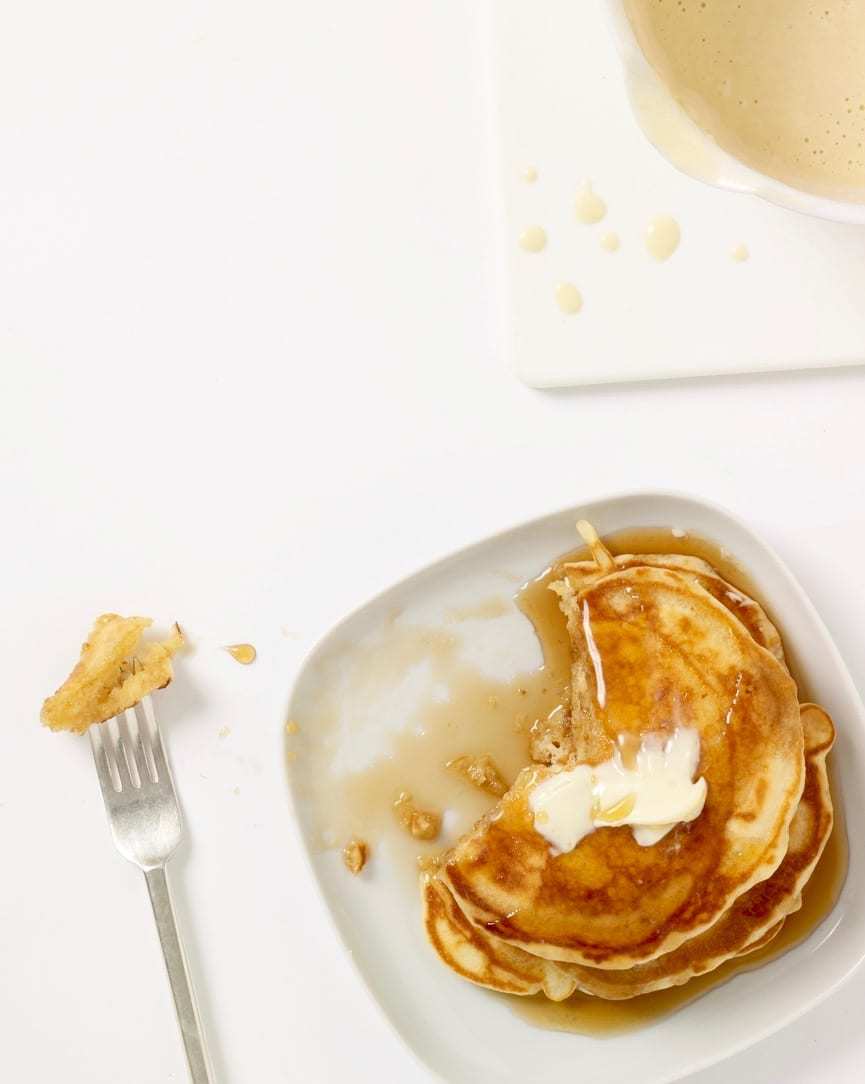 Pancakes from pantry ingredients pancakes on white plate with bite on fork with batter in background