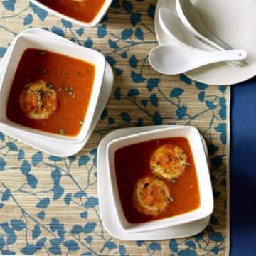 two bowls with tomato soup and cheese dumplings