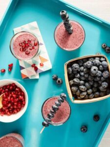 Overhead shot of Blueberry Ginger Sizzle Smoothies on teal platter