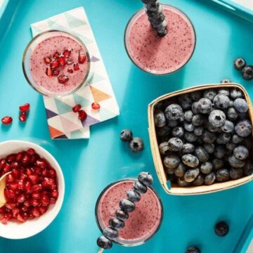 Overhead shot of Blueberry Ginger Sizzle Smoothies on teal platter