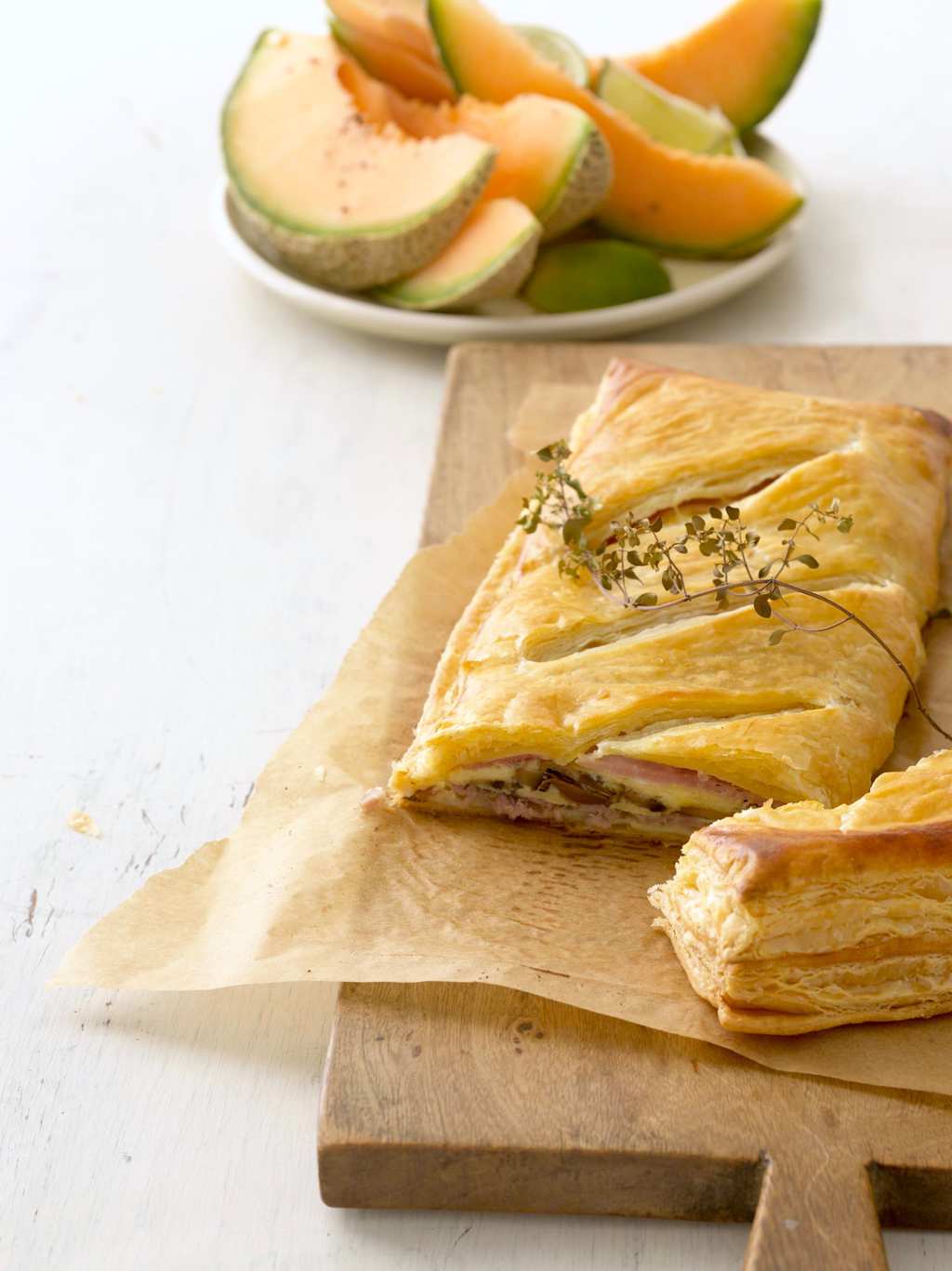 Breakfast Turnover cut into on a board fruit in background
