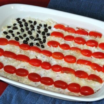 7 layer dip decorated with tomatoes and beans as an American flag