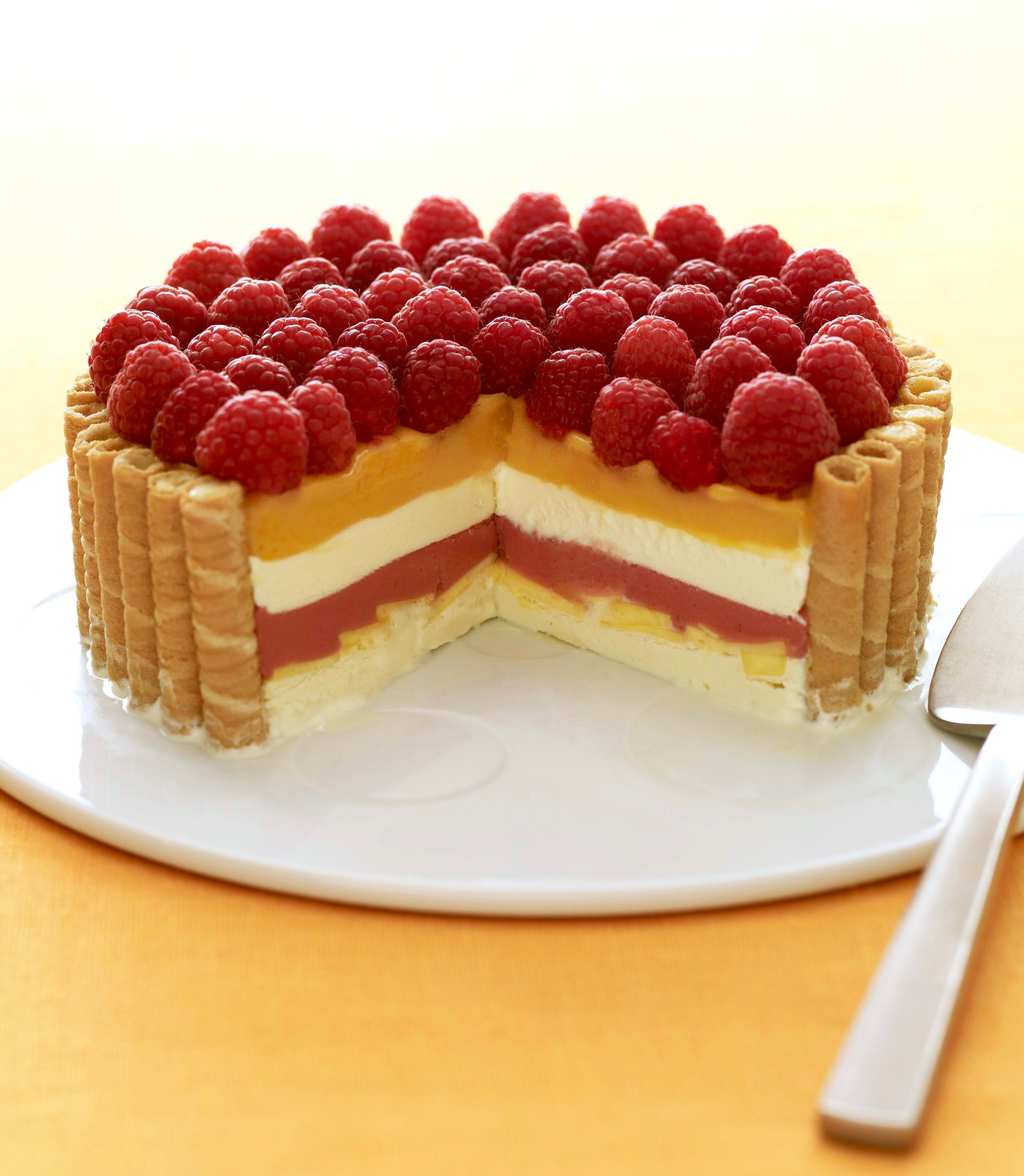 Fruit and Cream Icebox Cake with Mango and Raspberries on white plate and yellow linen with piece cut out