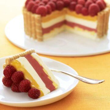 Slice of layered icebox cake with raspberries and mangos