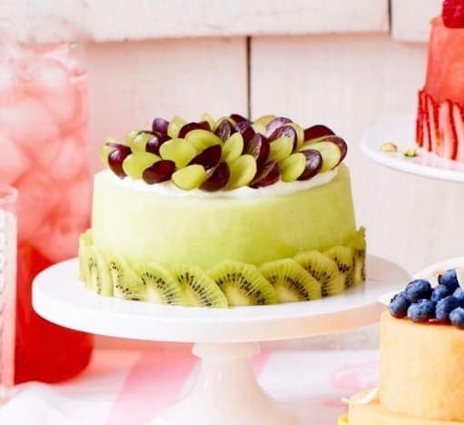 Honeydew Cake on white cake stand.
