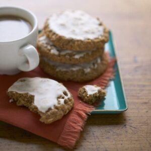 Iced Oatmeal Cookies on teal platter with coffee