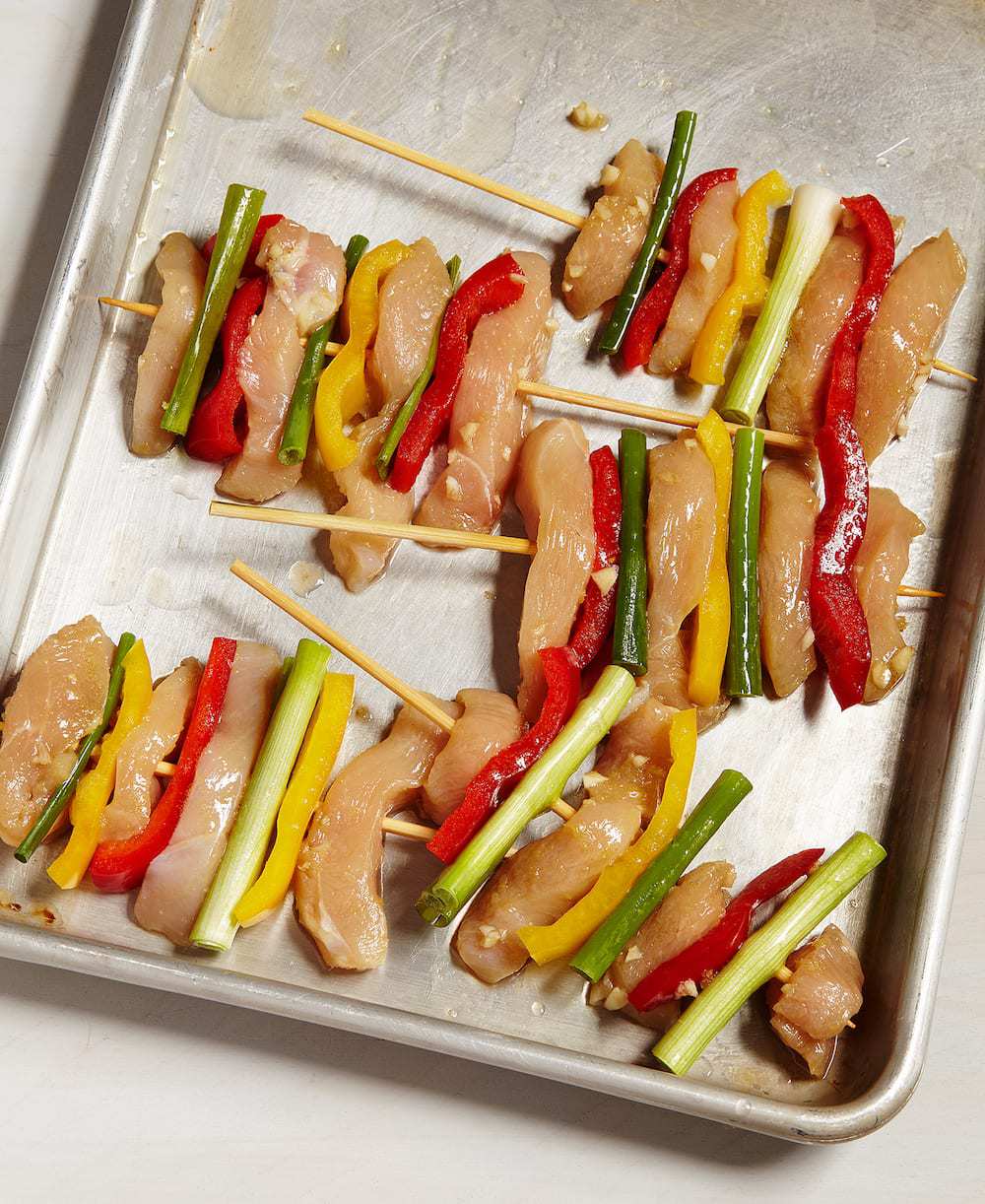 Korean BBQ Chicken Skewers with veggies on sheet tray ready to cook. 