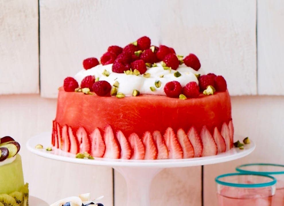 A fresh watermelon cake on cake stand.
