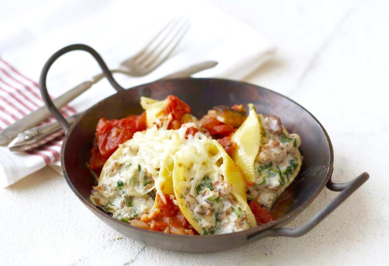 Easy Sausage Stuffed Shells in small iron baking dish. 