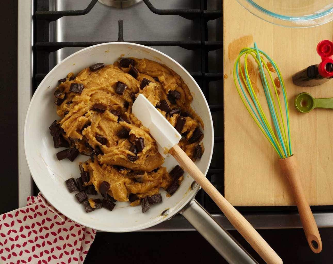 Chocolate chunk cookie dough in a skillet on the stove. 