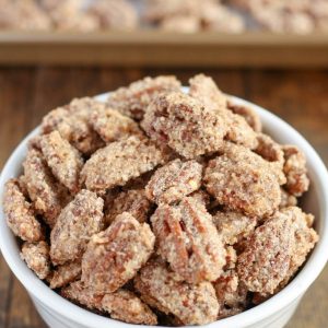 Candied Pecans in white bowl on wooden surface