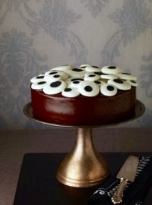 cake stand with chocolate cake and eyeball candy on top