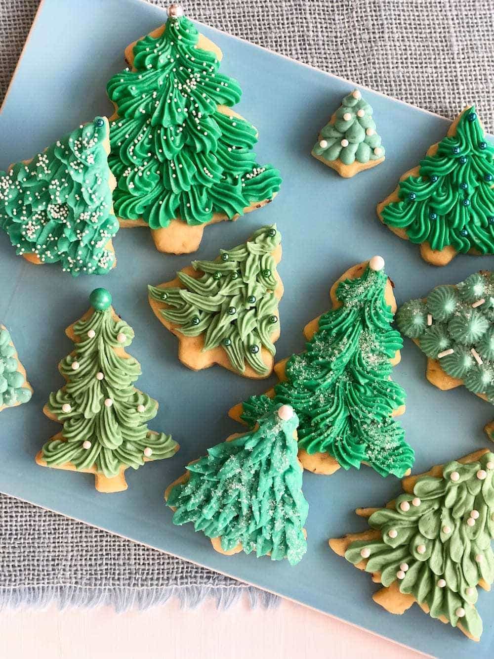 overhead view of Frosted Christmas tree sugar cookies on a blue platter