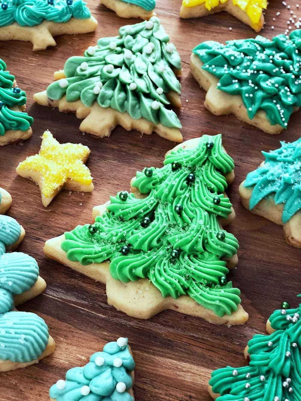 decorated Christmas tree cookies topped with cream cheese frosting. 