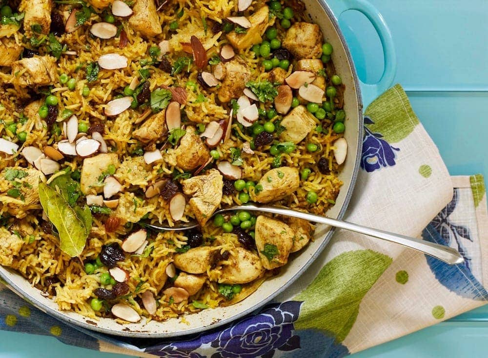 Chicken Biryani in a le creuset casserole on blue surface