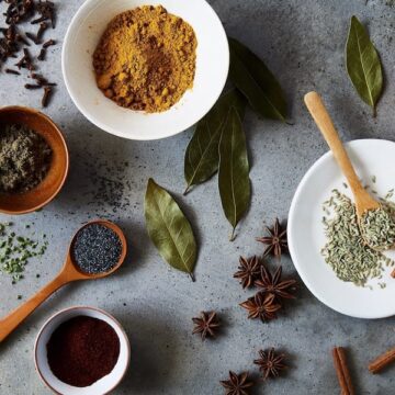 Spices in bowl and spoons on surface