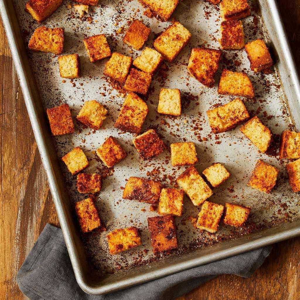 Cornbread croutons on baking sheet