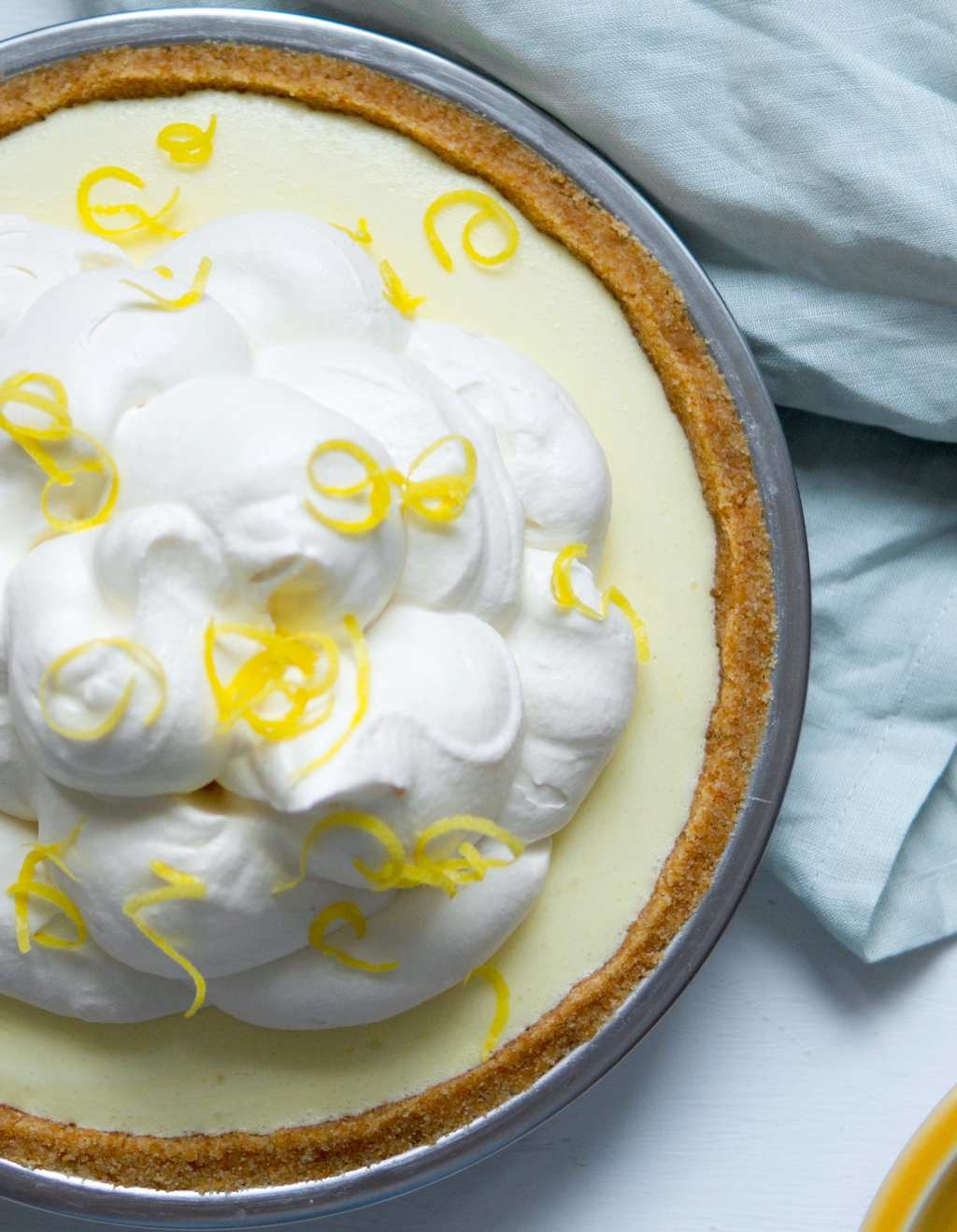 An overhead view of a no bake lemon icebox pie topped with whipped cream. 