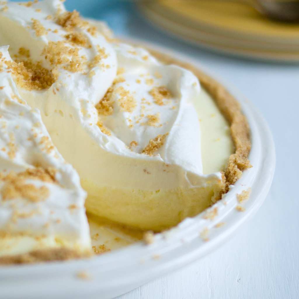 No-bake lemon icebox pie in white pie pan with slice removed