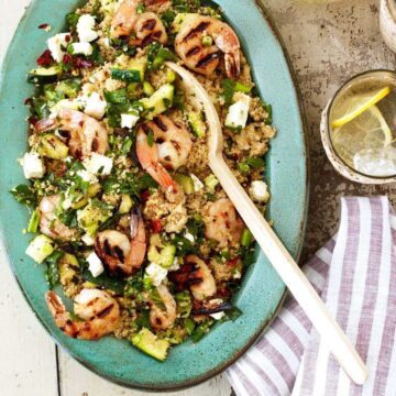 Grilled shrimp and zucchini couscous dinner on blue plate
