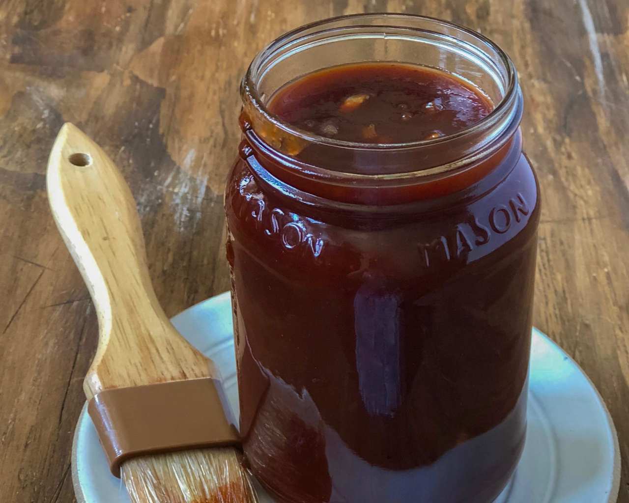 Memphis BBQ Sauce in mason jar with brush on turquoise plate