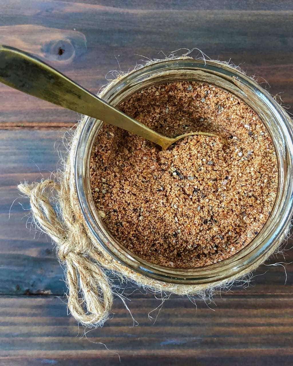 Dry rub in jar with bronze spoon overhead