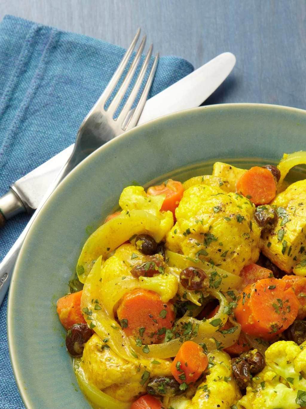 A serving of slow cooker chicken curry in green bowl close crop