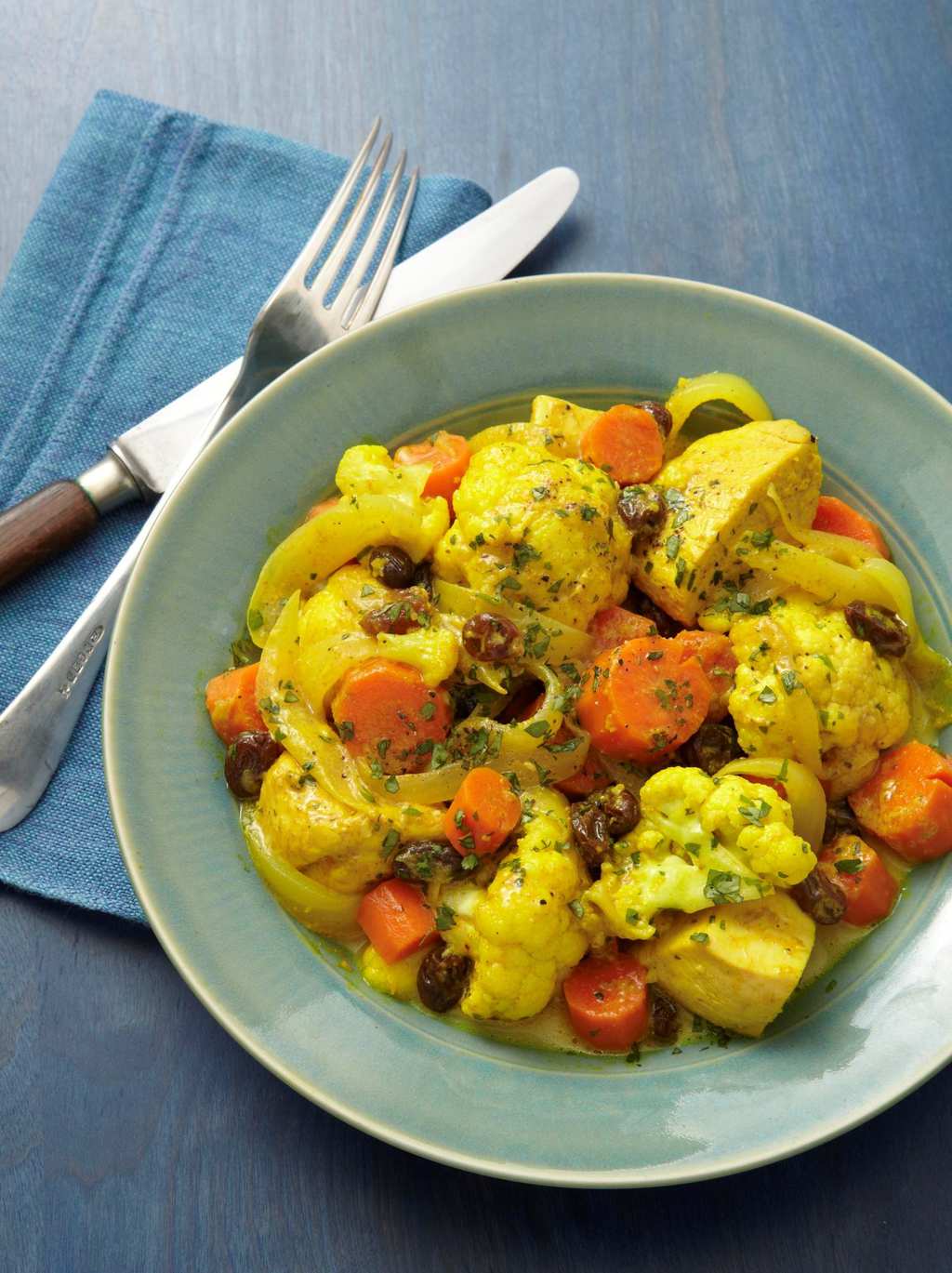 Healthy Chicken Curry in green bowl with blue background
