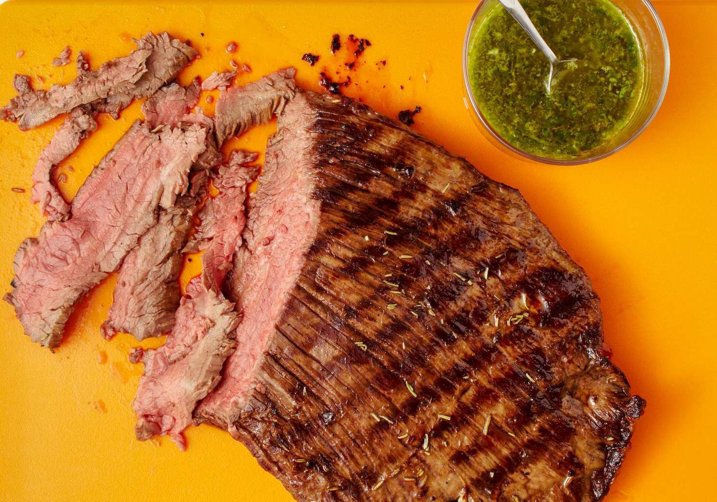 sliced grilled flank steak with salsa verde