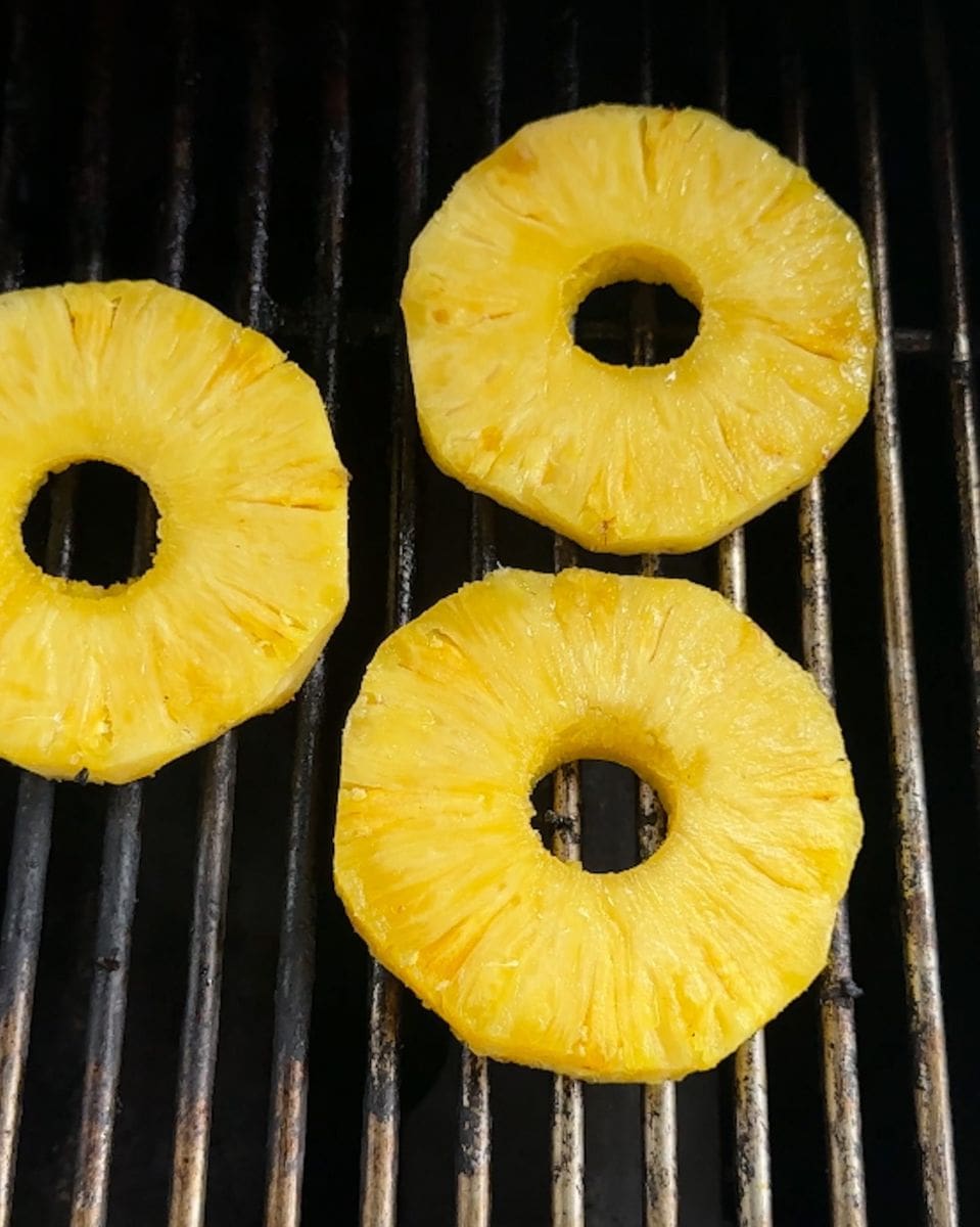 Three pineapple rings on a grill.