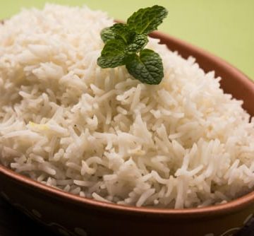 white rice in brown bowl with green garnish