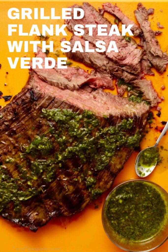 grilled flank steak with salsa verde on cutting board