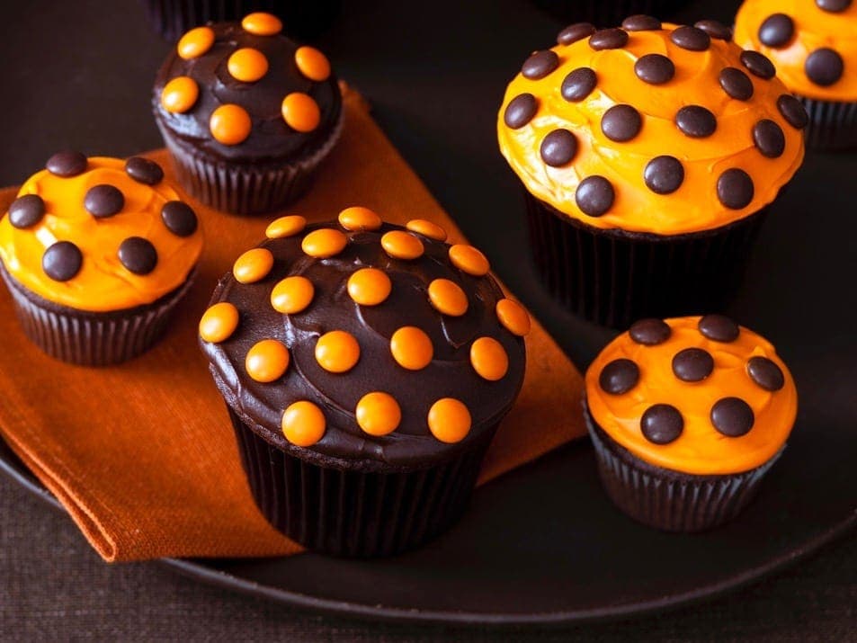 close up of halloween cupcakes with orange and brown frosting