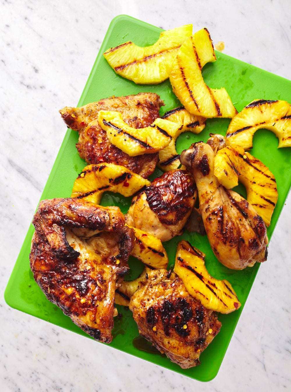 Soy and ginger marinated tropical chicken with grilled pineapple on green cutting board