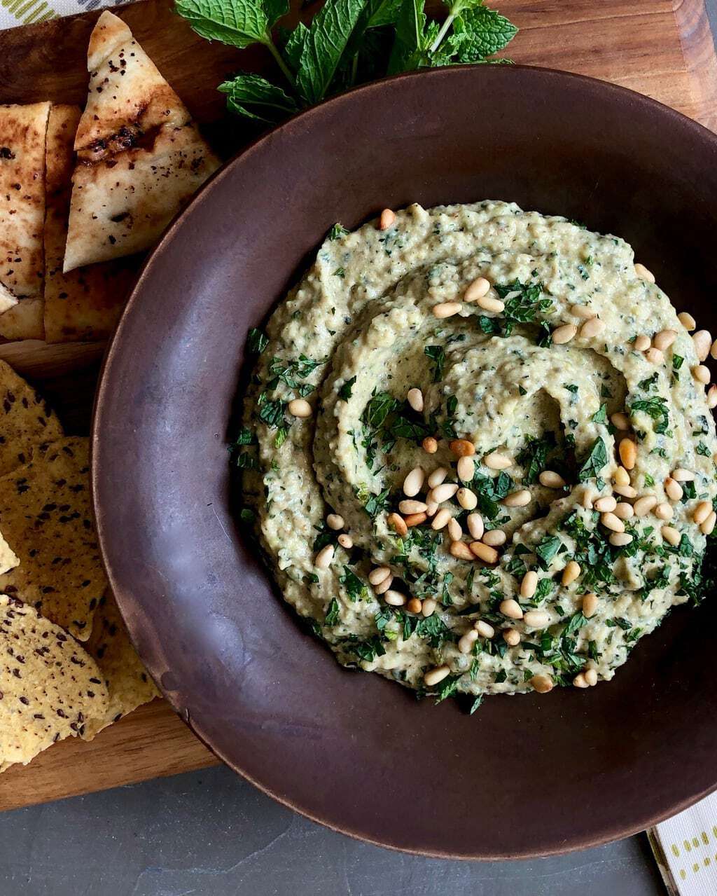 grilled zucchini baba ganoush in brown bowl and topped with pepitas and parsley