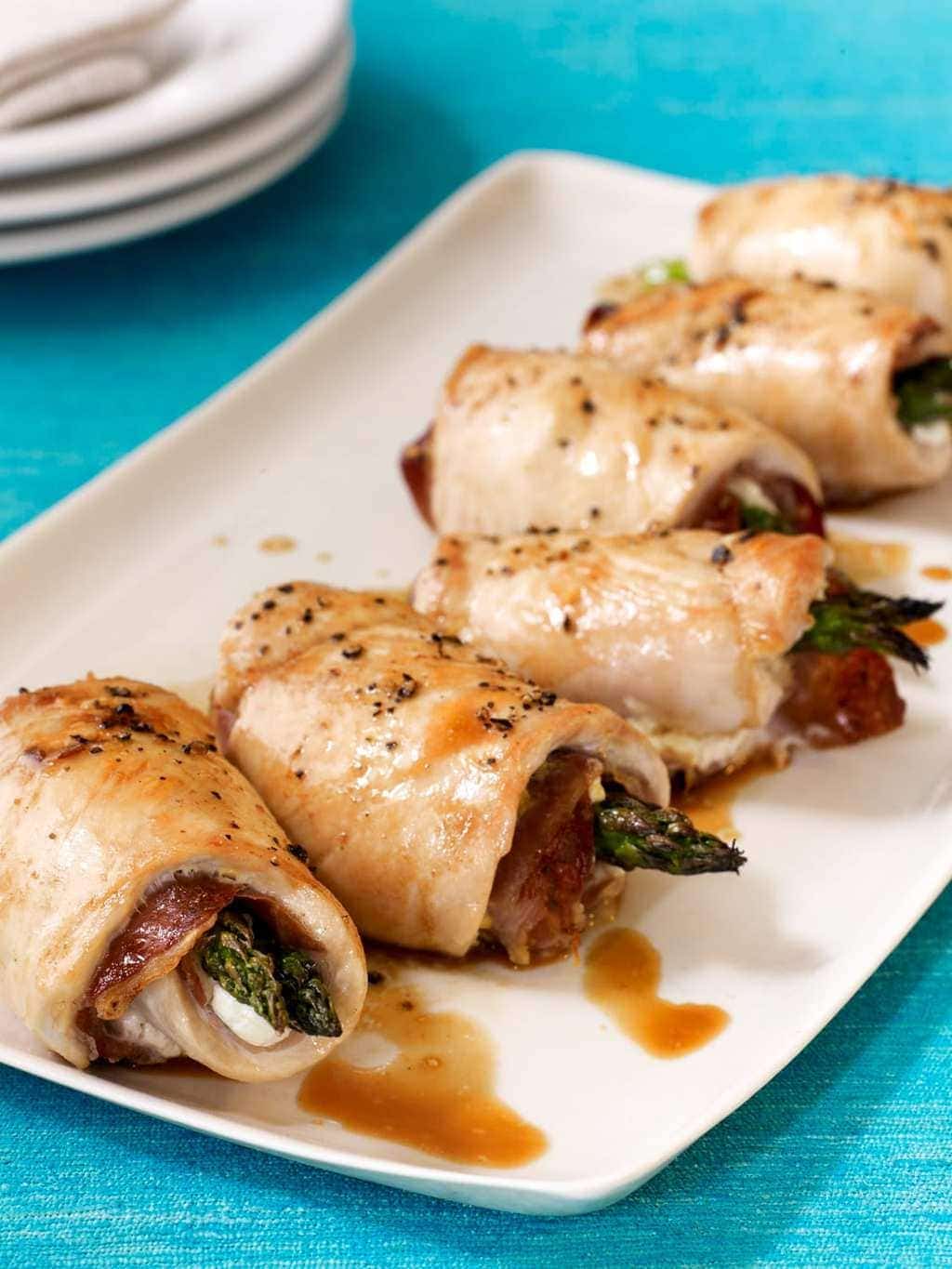 chicken roll ups on a plate with blue surface