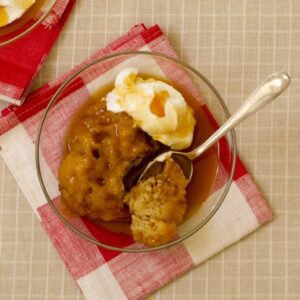 apple dumplings in a bowl with cream and cider sauce