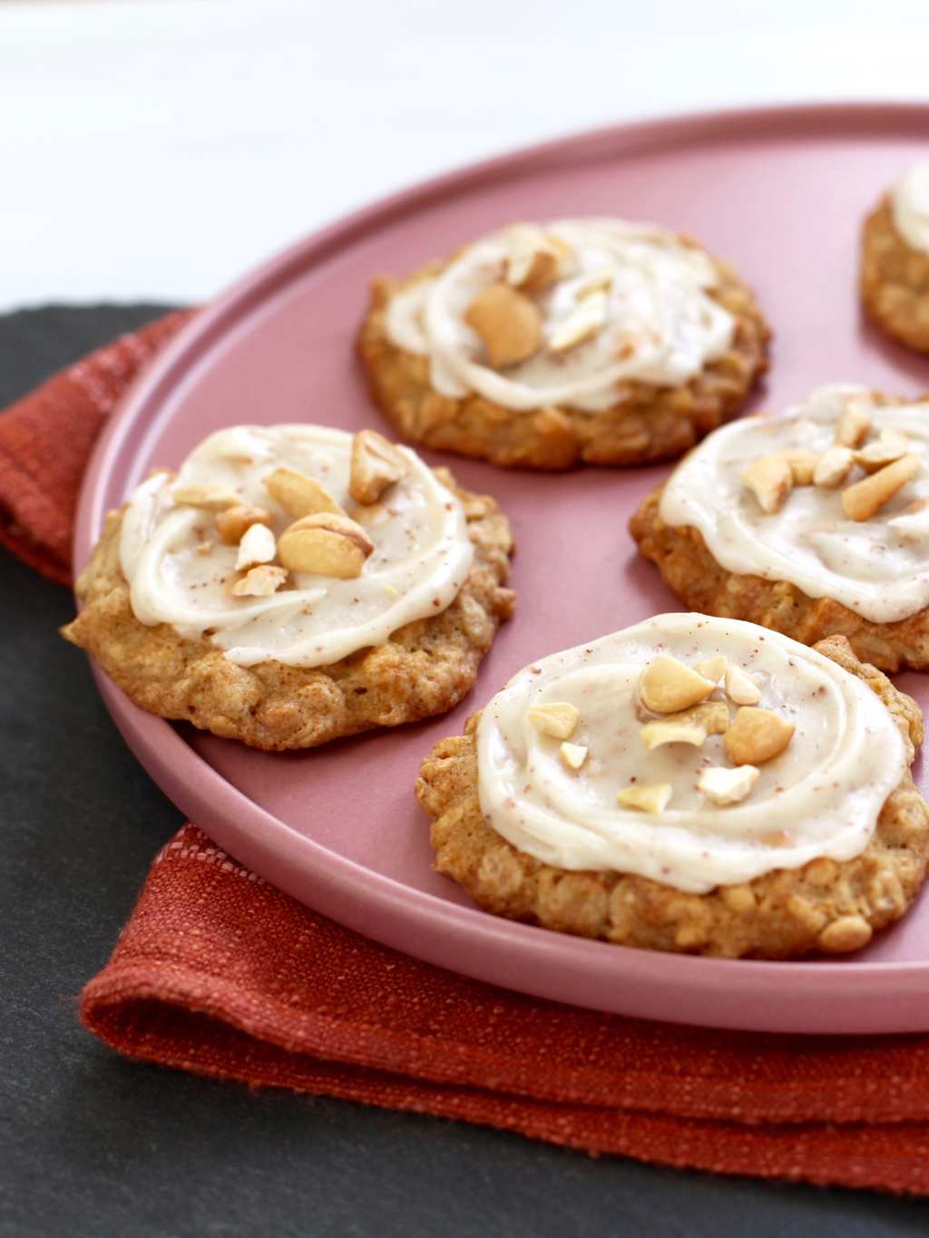 Cashew Cookies with Brown Butter Frosting on a pink plate close crop