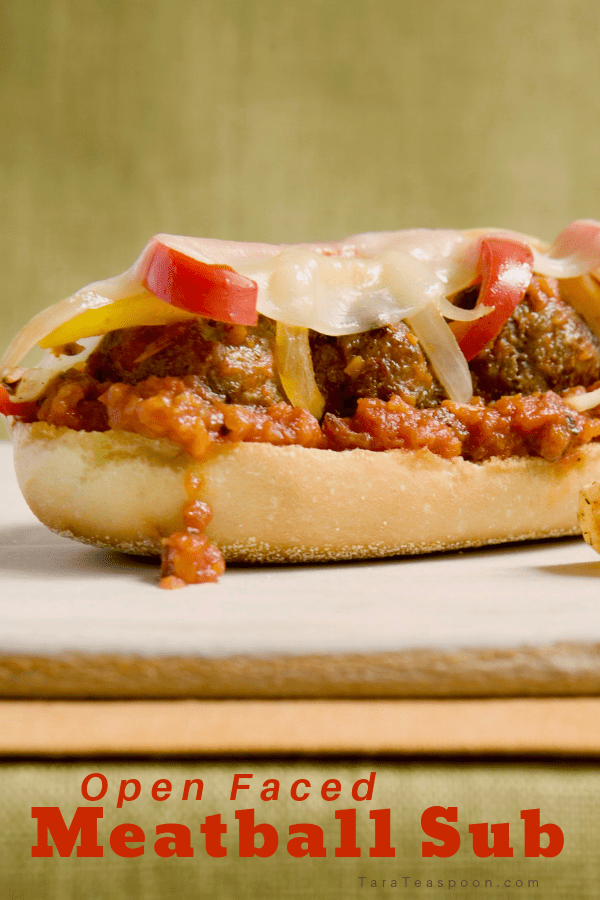 A delicious open face meatball sub on a cutting board pin