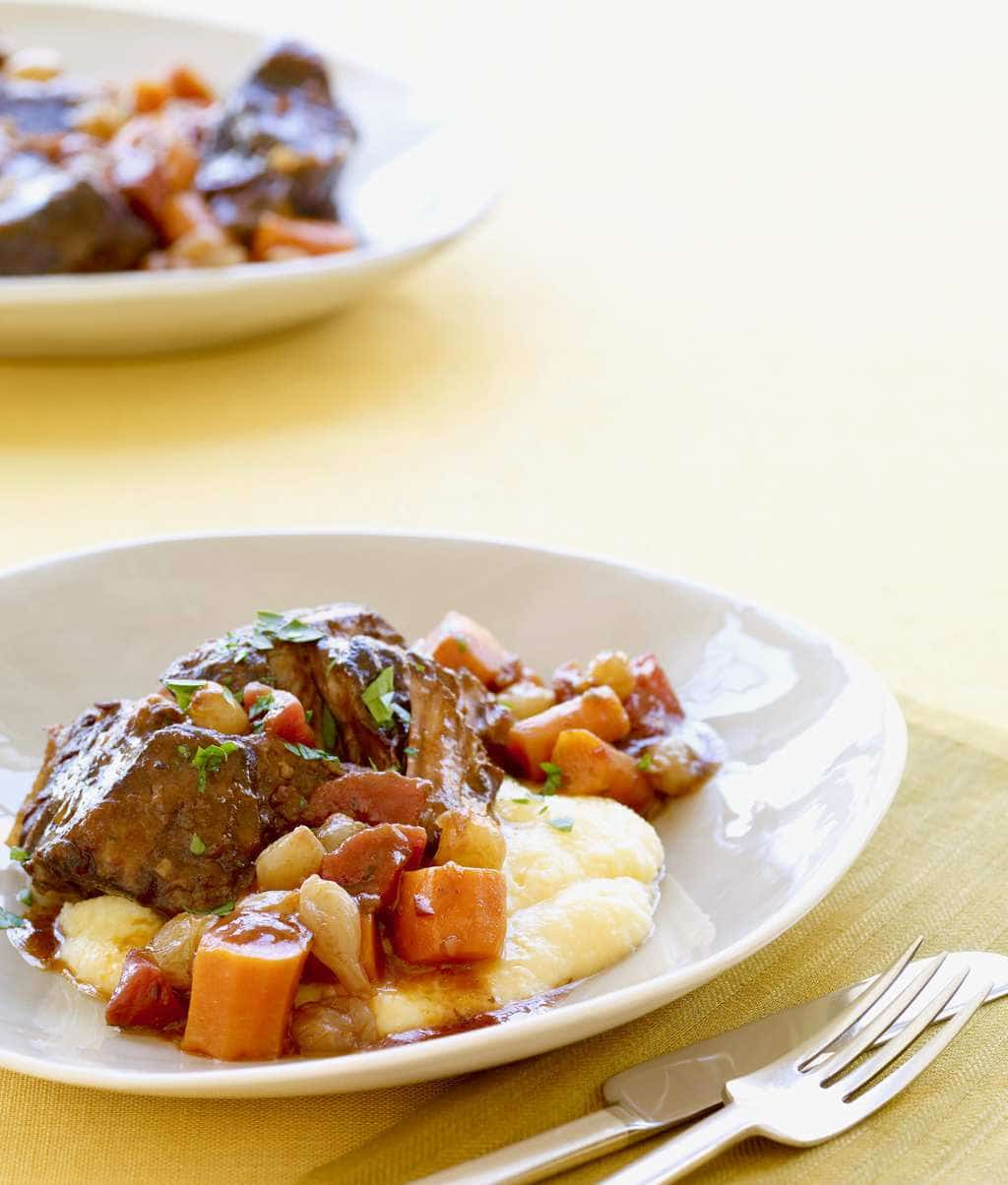 Slow cooker short ribs with cheesy polenta in a white bowl