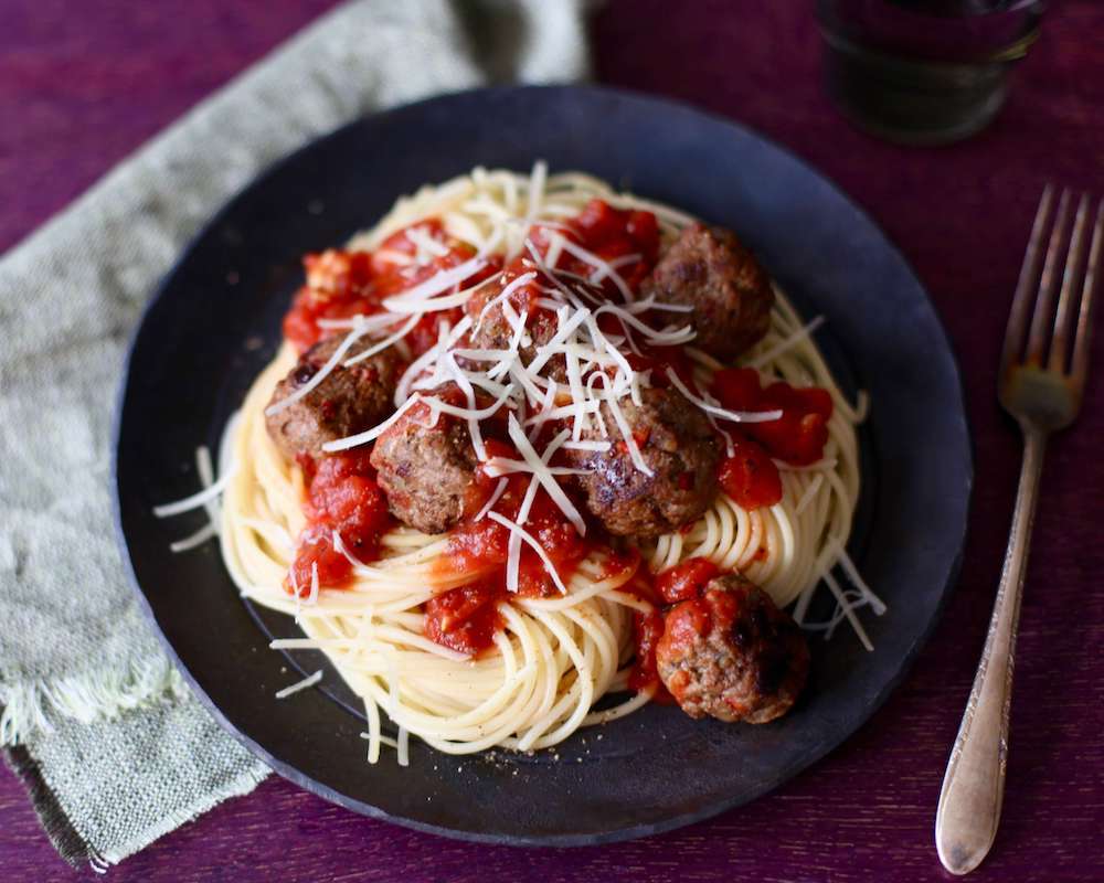 Meatballs on spaghetti on black plate