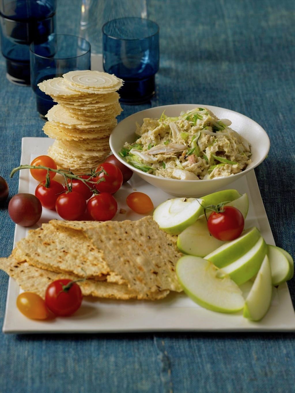 Crab dip with crackers, veggies, fruit on white tray