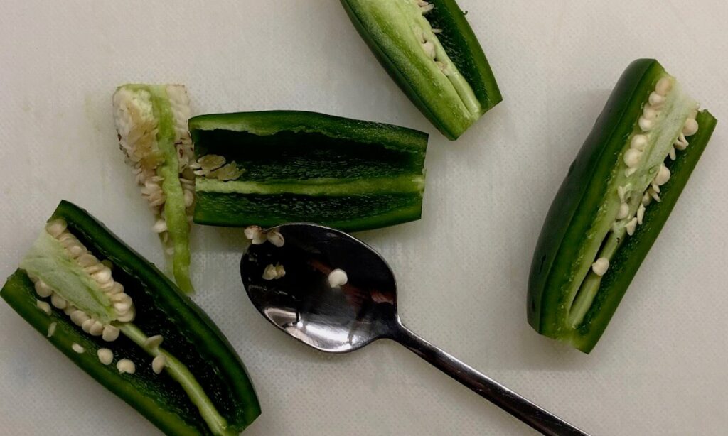 jalapeno peppers being sliced and de-seeded